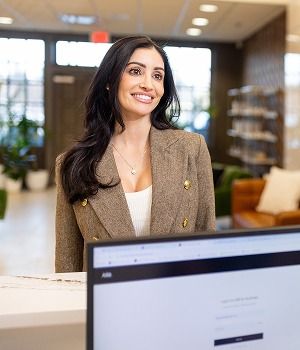 Smiling woman at reception desk in an office.