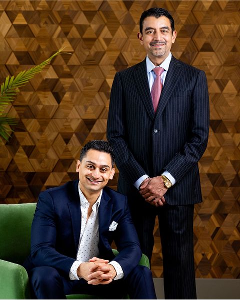 Two men in formal attire, standing and posing.