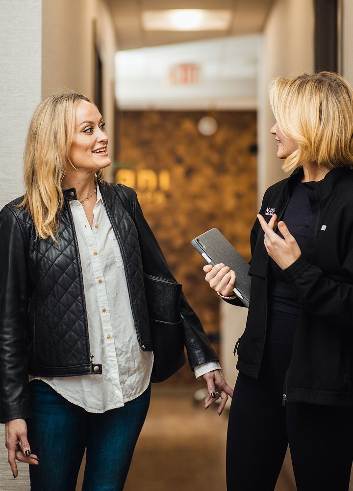 Two women chatting in a professional setting.