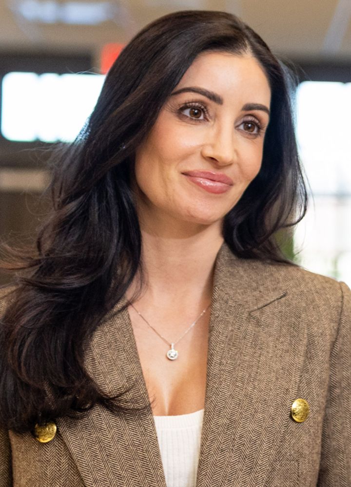 Woman with long dark hair in a blazer.