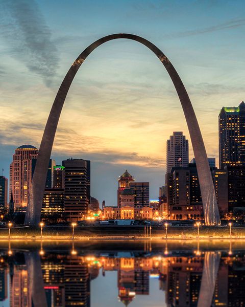 St. Louis Gateway Arch at sunset over water.
