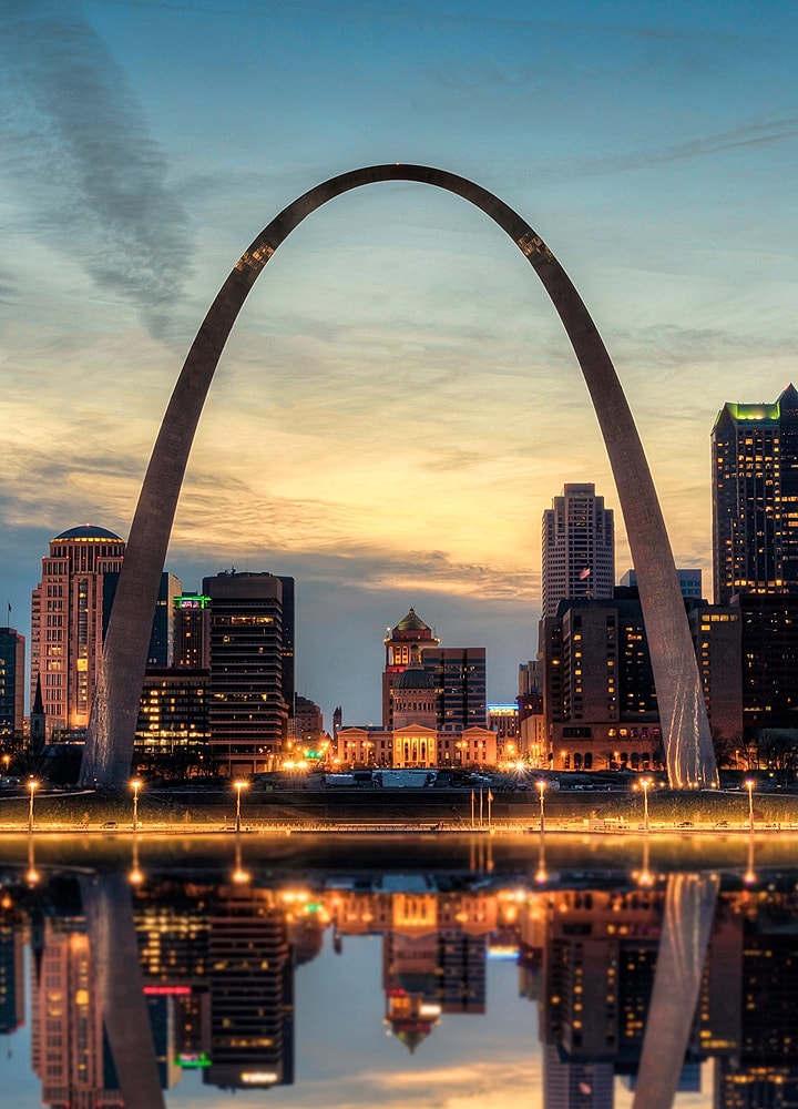 St. Louis Arch at sunset, reflecting in water.