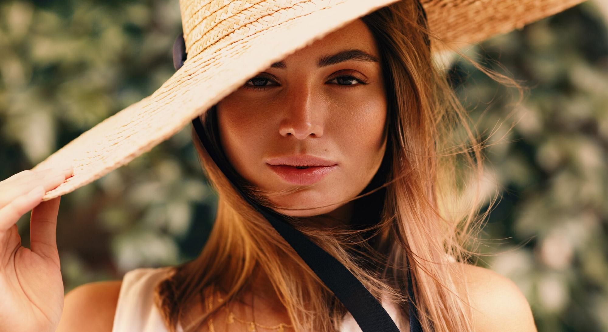 Woman wearing a wide-brimmed hat outdoors.