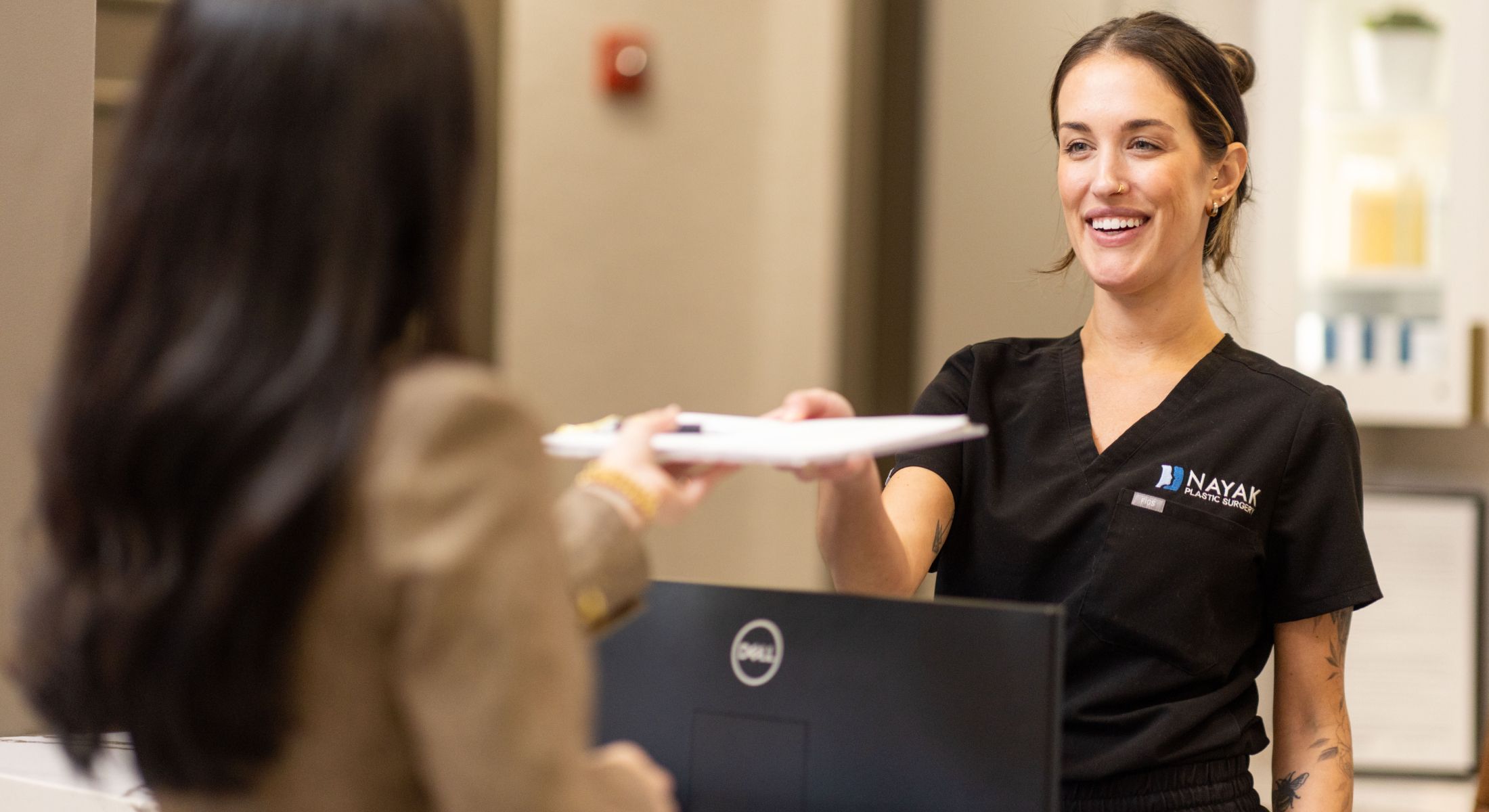 Staff member assisting customer at reception desk