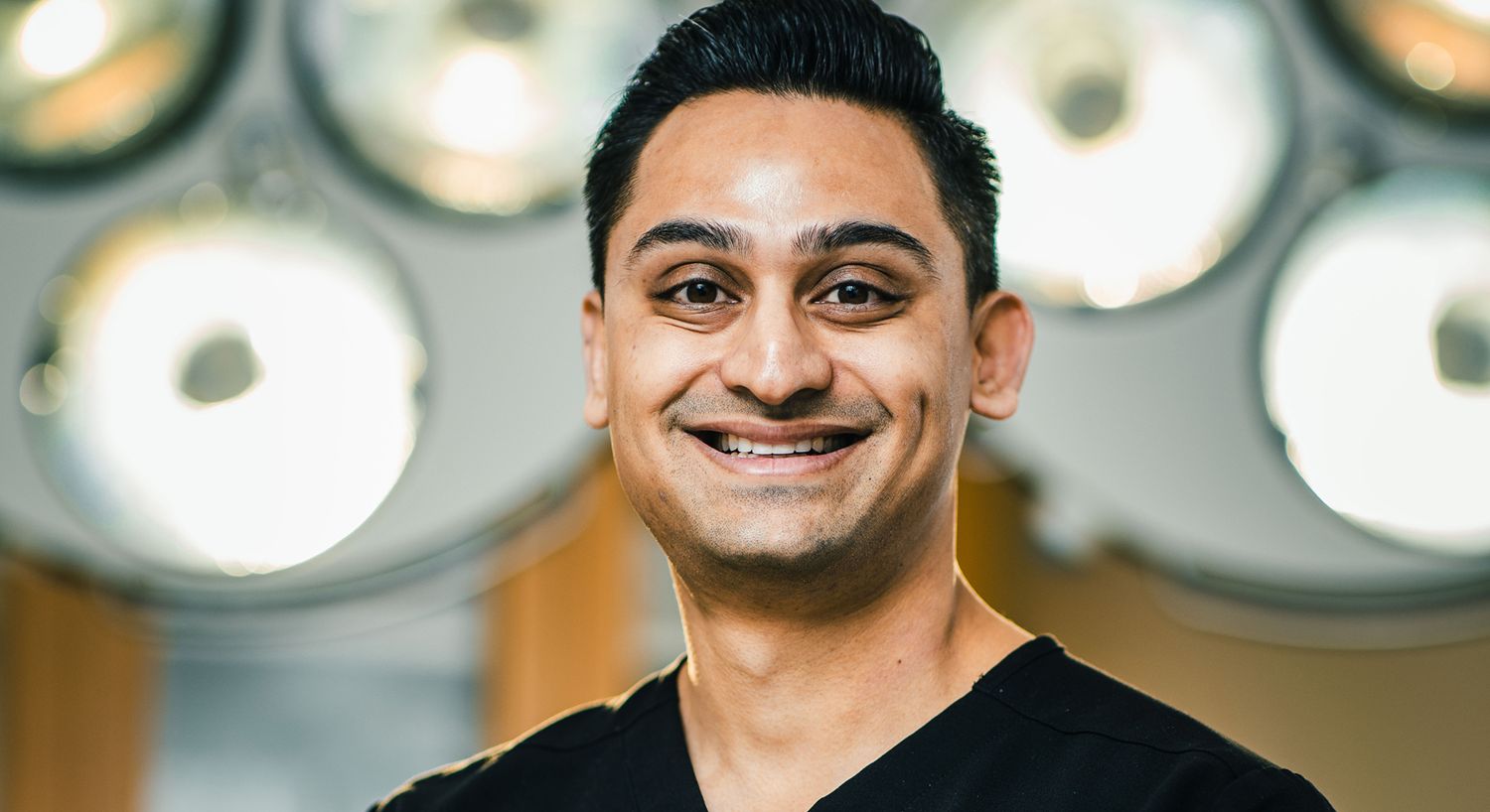 Smiling medical professional in surgical environment.