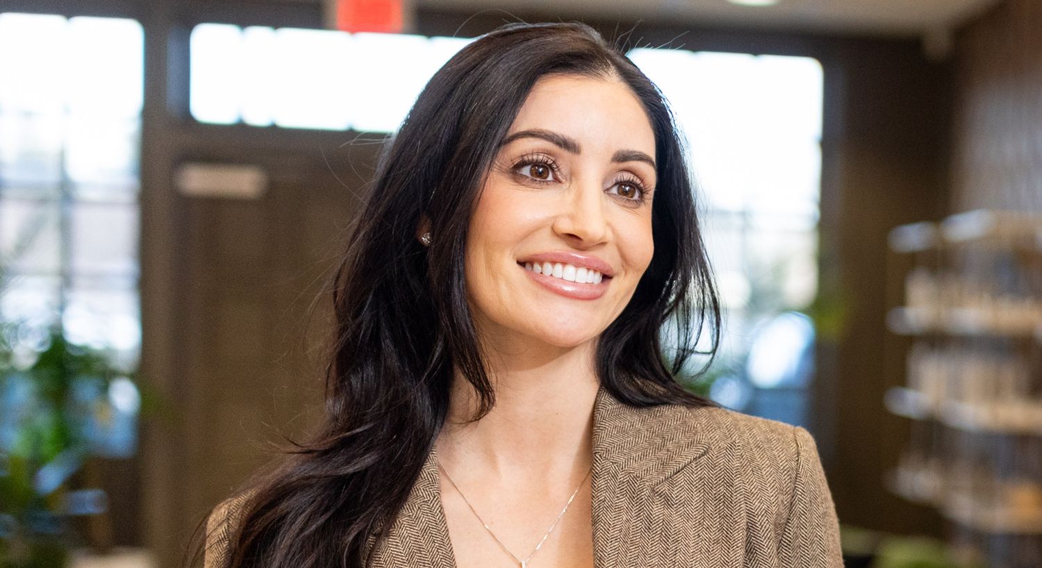 Smiling woman in professional attire indoors.
