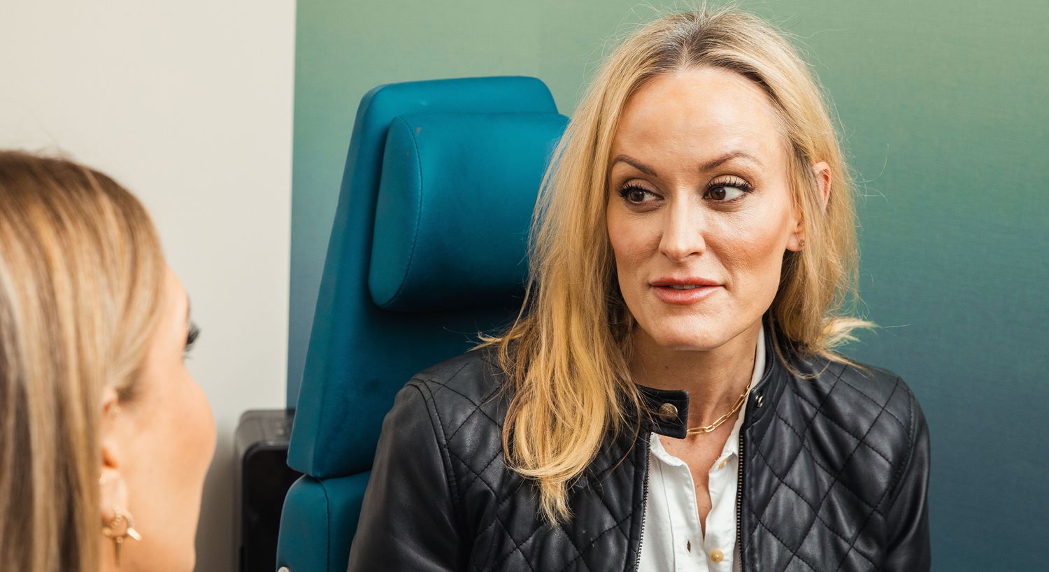 Woman conversing with another person in office.