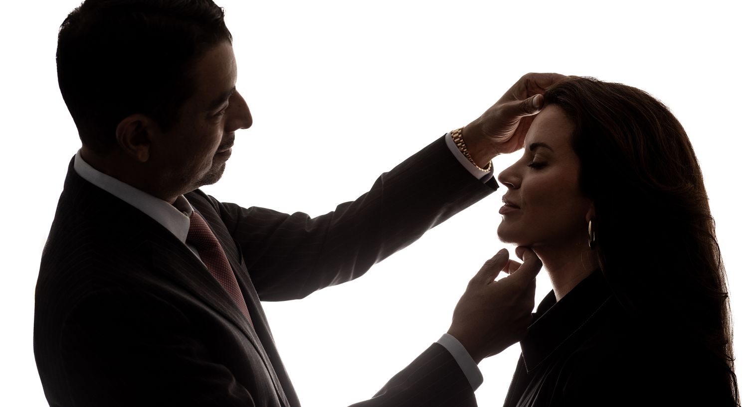 Silhouette of a man and woman in profile.